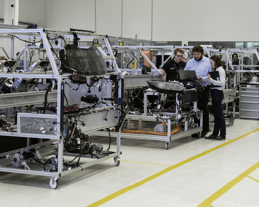Ingénieurs travaillant avec un ordinateur portable devant une ligne de production